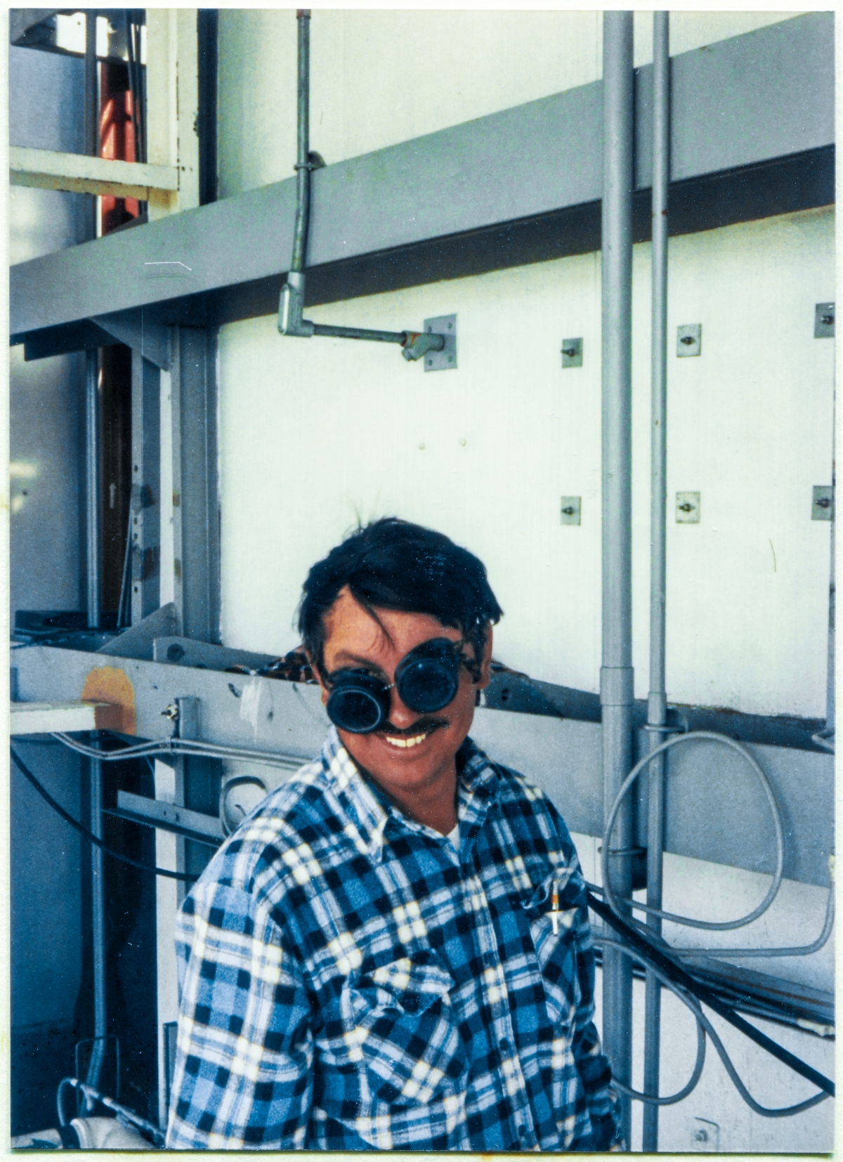 Image 065. Ironworker Gene Lockamy out of the Local 808 Union Hall working for Ivey's Steel Erectors at Space Shuttle Launch Complex 39-B, Kennedy Space Center, Florida, takes a momentary break from his work modifying the Rotating Service Structure in the area of the Girts which hold up the insulated metal paneling along the back side of the Payload Changeout Room, and unexpectedly pulls his cutting-torch goggles down at an absurd angle to laughingly oblige the photographer's request for an on-the-job photograph, up on high steel. Photograph by James MacLaren. Image 065. Ironworker Gene Lockamy out of the Local 808 Union Hall working for Ivey's Steel Erectors at Space Shuttle Launch Complex 39-B, Kennedy Space Center, Florida, takes a momentary break from his work modifying the Rotating Service Structure in the area of the Girts which hold up the insulated metal paneling along the back side of the Payload Changeout Room, and unexpectedly pulls his cutting-torch goggles down at an absurd angle to laughingly oblige the photographer's request for an on-the-job photograph, up on high steel. Photograph by James MacLaren.